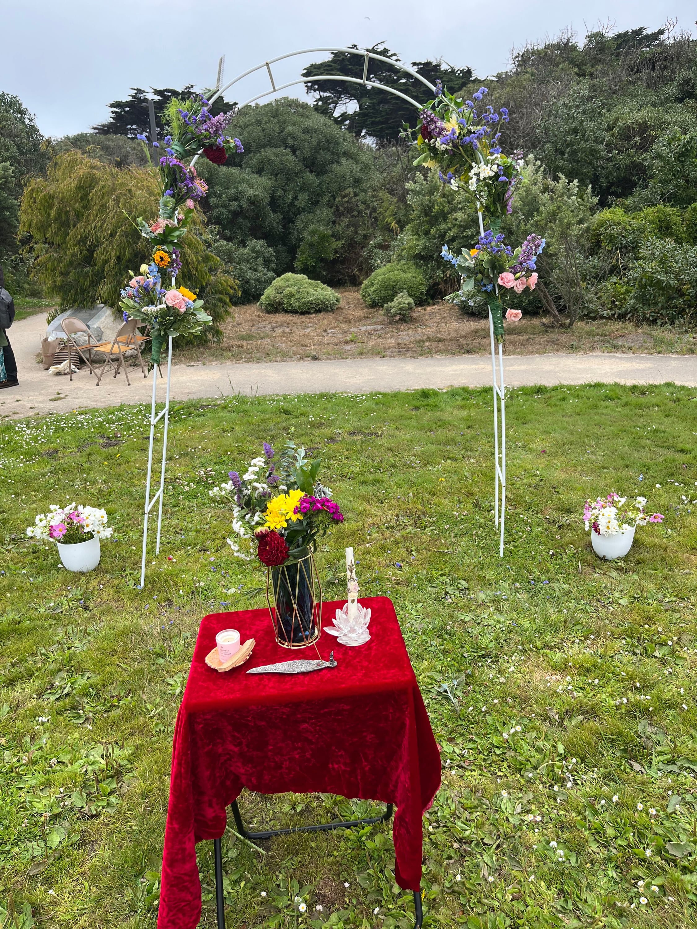 Flower-draped wedding arch and altar table set up on the grass for an outdoor San Francisco wedding