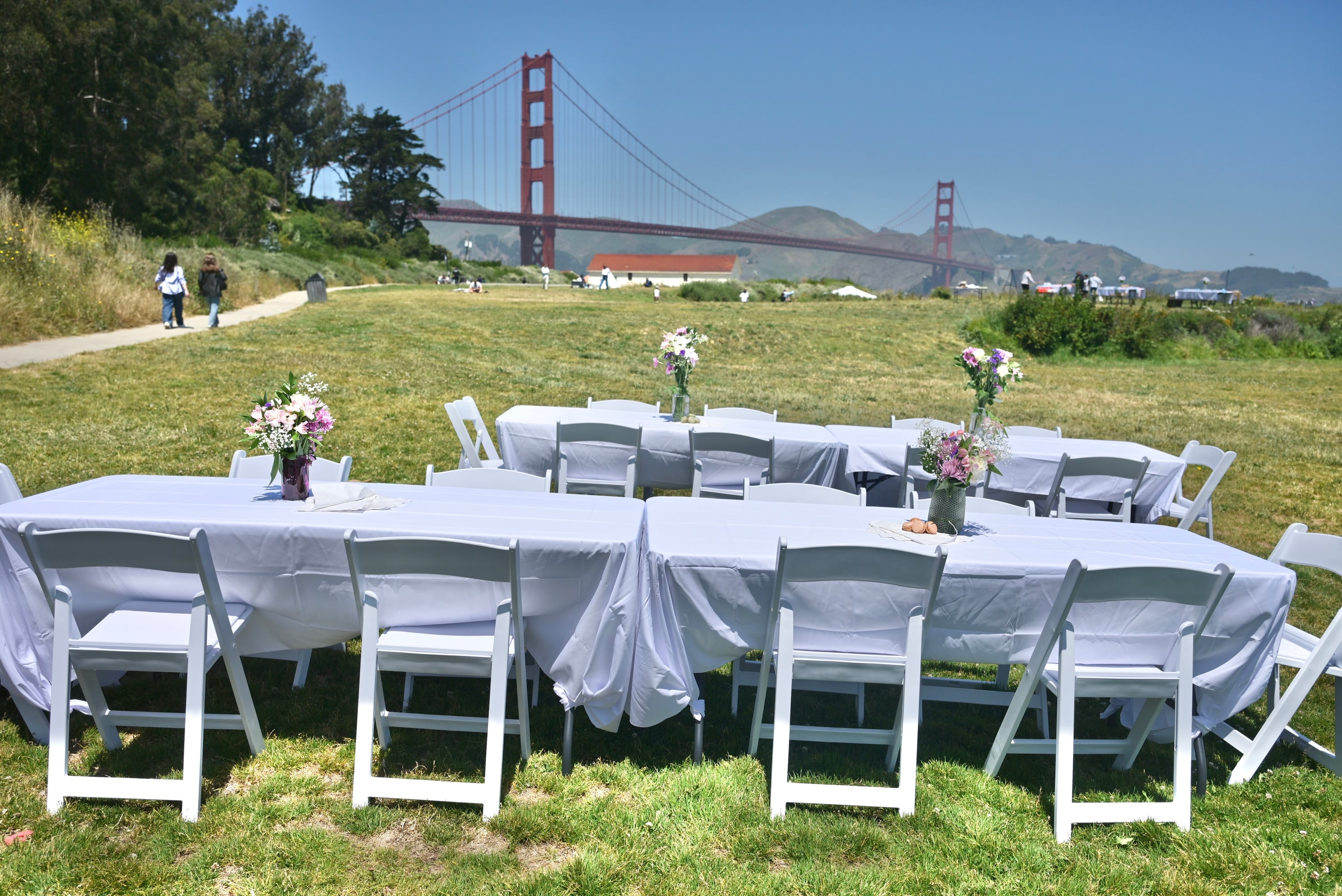 Tables and chairs set up on the grass with the Golden Gate Bridge in the background